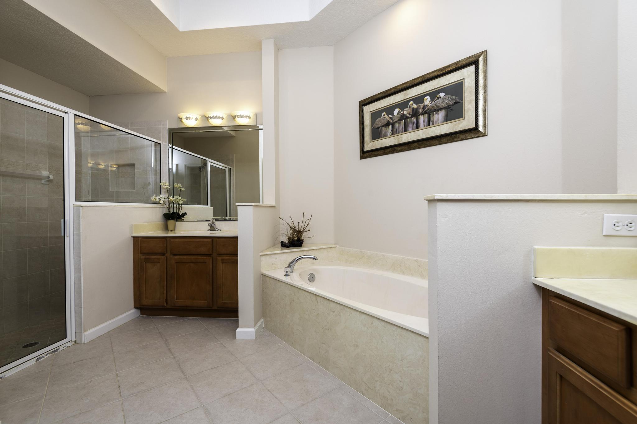 511 Northwest Red Pine Way Jensen Beach, FL 34957 - Photo 30 of 60 a bathroom with a tub a sink and mirror