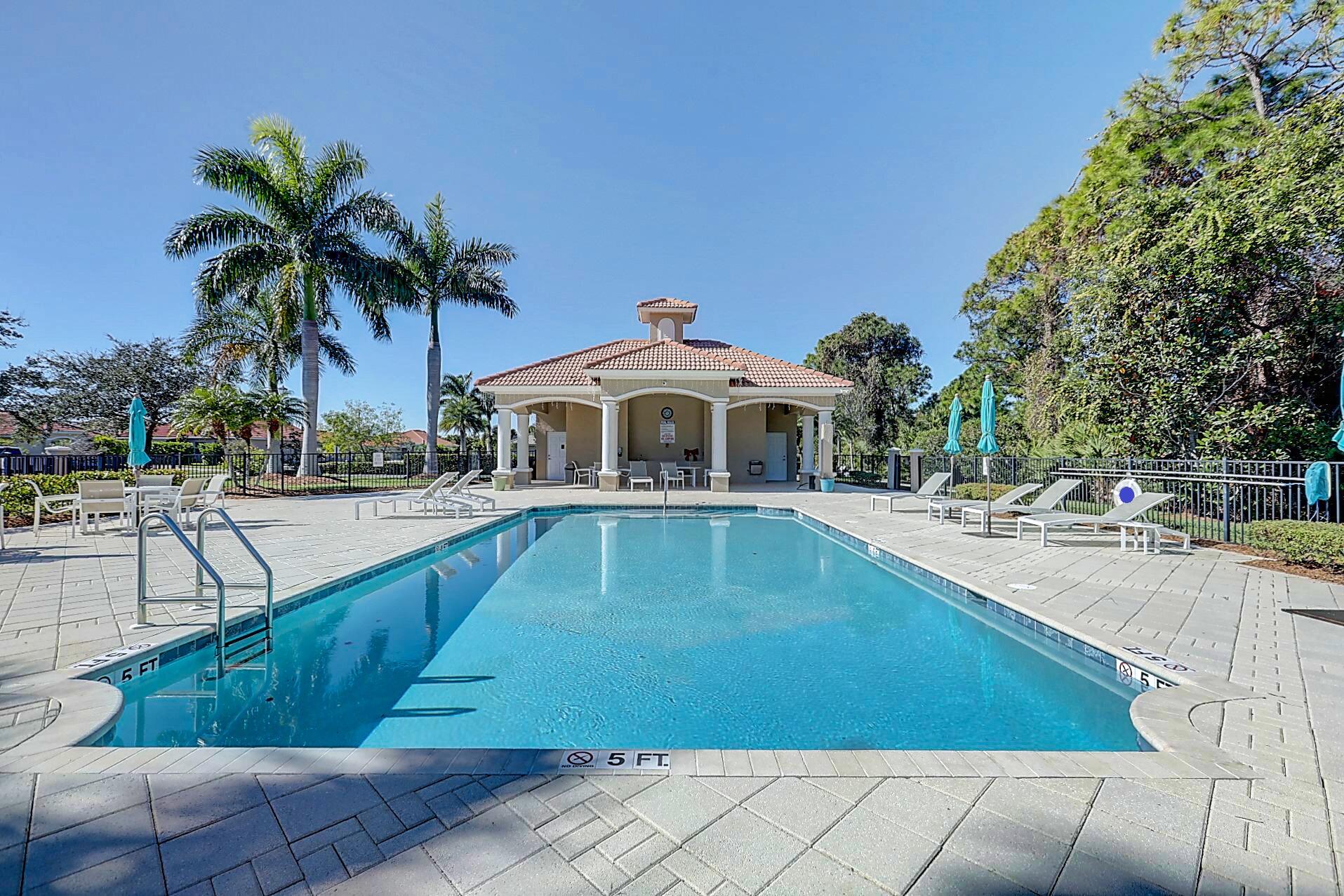 511 Northwest Red Pine Way Jensen Beach, FL 34957 - Photo 51 of 60 a swimming pool with outdoor seating and yard