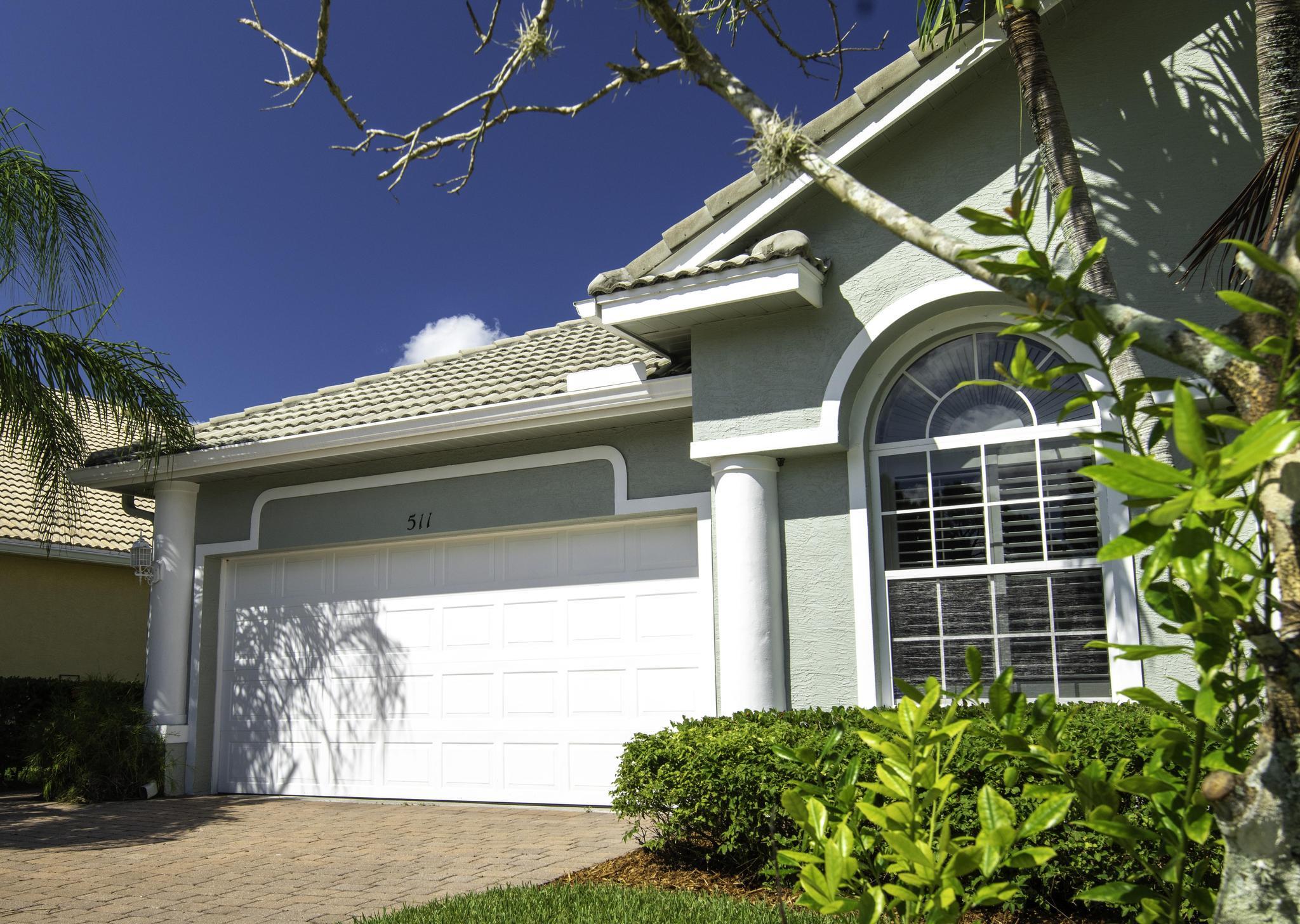 511 Northwest Red Pine Way Jensen Beach, FL 34957 - Photo 6 of 60 a front view of a house with a yard