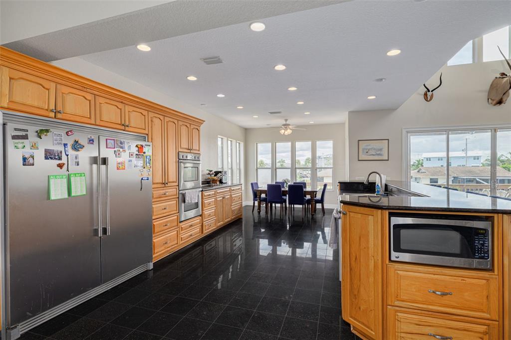 8100 Brighton Drive Port Richey, FL 34668 - Photo 50 of 68 a kitchen with stainless steel appliances kitchen island granite countertop a refrigerator and a stove top oven