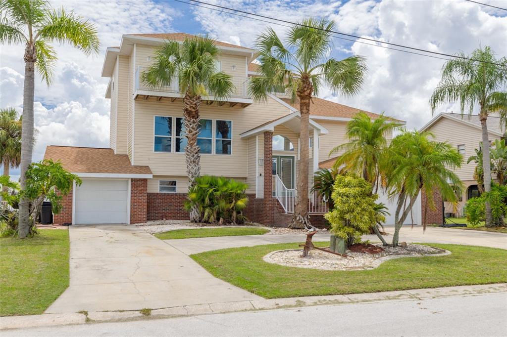 8100 Brighton Drive Port Richey, FL 34668 - Photo 58 of 68 a front view of a house with a yard and palm trees