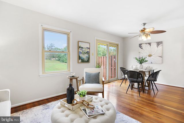 a dining room with furniture wooden floor a potted plant and a chandelier