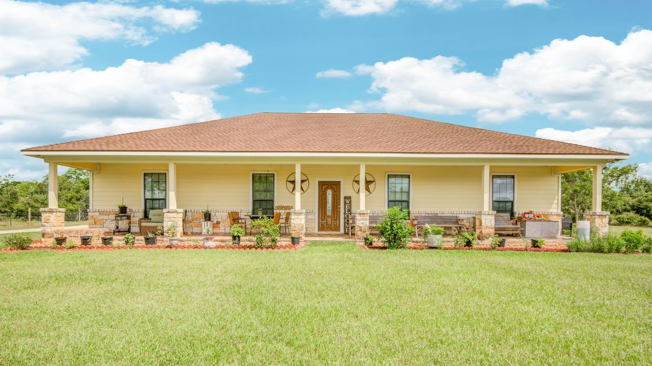 a front view of house with outdoor seating and barbeque oven