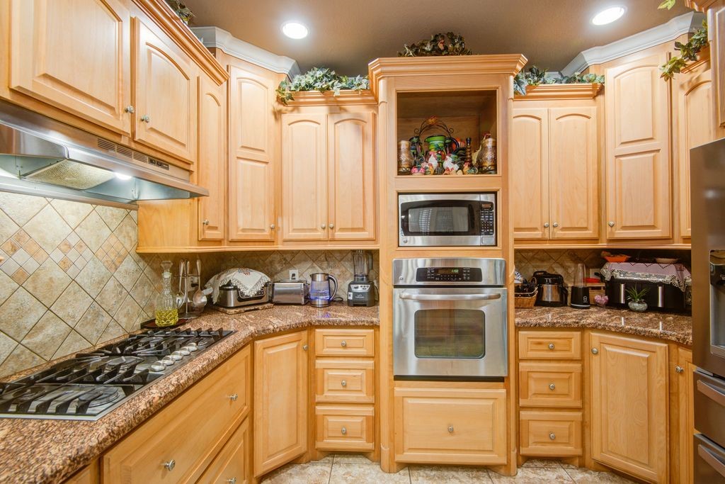 24910 Farm To Market 2004 Angleton, TX 77515 - Photo 16 of 50 a kitchen with stainless steel appliances granite countertop a stove a sink and a microwave
