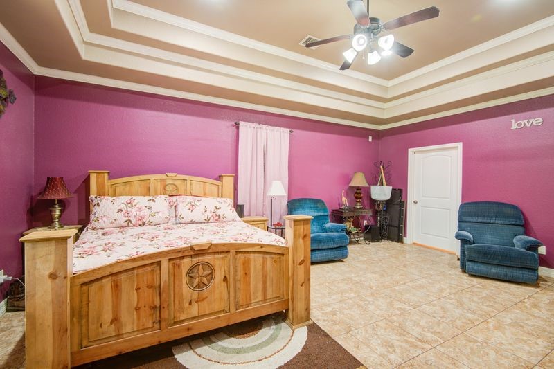 24910 Farm To Market 2004 Angleton, TX 77515 - Photo 20 of 50 a bedroom with a bed dresser and a chandelier