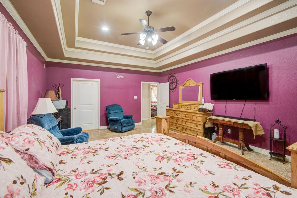 24910 Farm To Market 2004 Angleton, TX 77515 - Photo 21 of 50 a bedroom with a bed and a flat screen tv