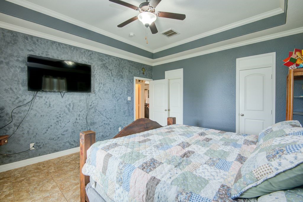 24910 Farm To Market 2004 Angleton, TX 77515 - Photo 28 of 50 a bedroom with a bed and a flat screen tv