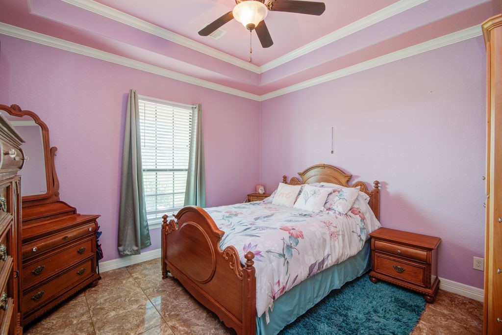 24910 Farm To Market 2004 Angleton, TX 77515 - Photo 31 of 50 a bedroom with a bed and a chandelier