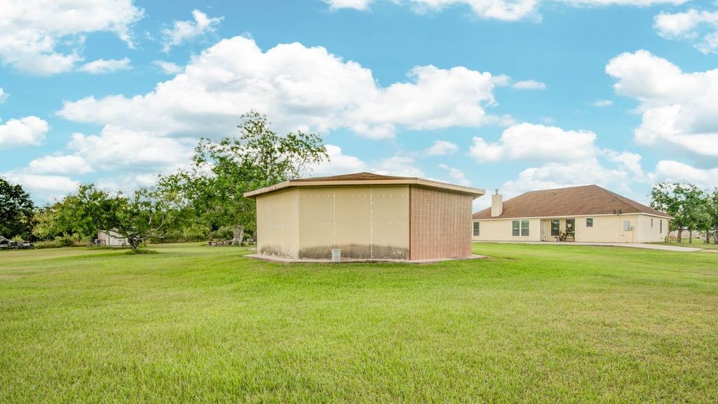 24910 Farm To Market 2004 Angleton, TX 77515 - Photo 45 of 50 a big white house with a big yard and large trees with wooden fence