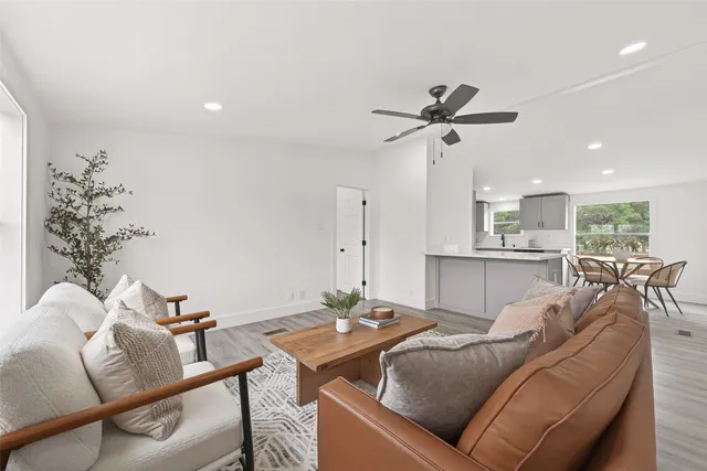 a living room with furniture a chandelier fan and a dining table