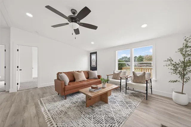 a living room with furniture and view of wooden floor