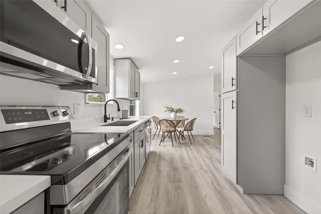 a kitchen with a sink appliances and cabinets