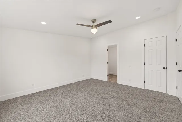 an empty room with a ceiling fan and a window
