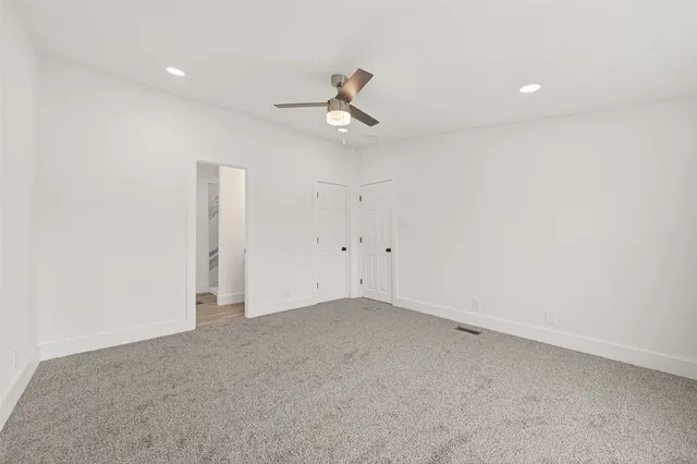 an empty room with ceiling fan and window