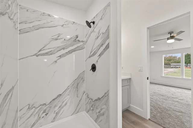 a view of a hallway with a white walls and wooden floor