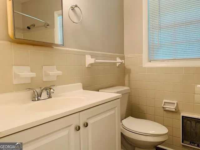 a bathroom with a sink a toilet and mirror