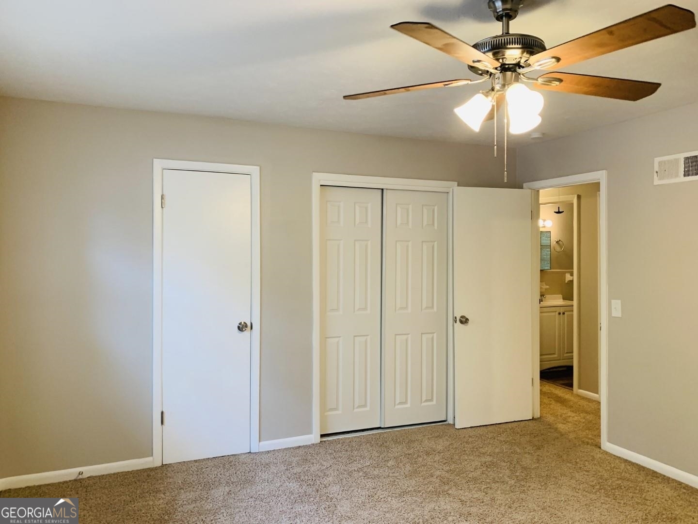 1069 Laurel Lane Northwest, Unit B Conyers, GA 30012 - Photo 18 of 28 an empty room with windows and fan