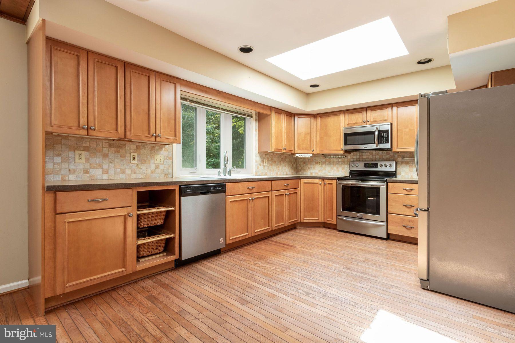 4887 Danielle Drive Doylestown, PA 18902 - Photo 22 of 35 a kitchen with stainless steel appliances granite countertop a stove top oven a sink and a refrigerator