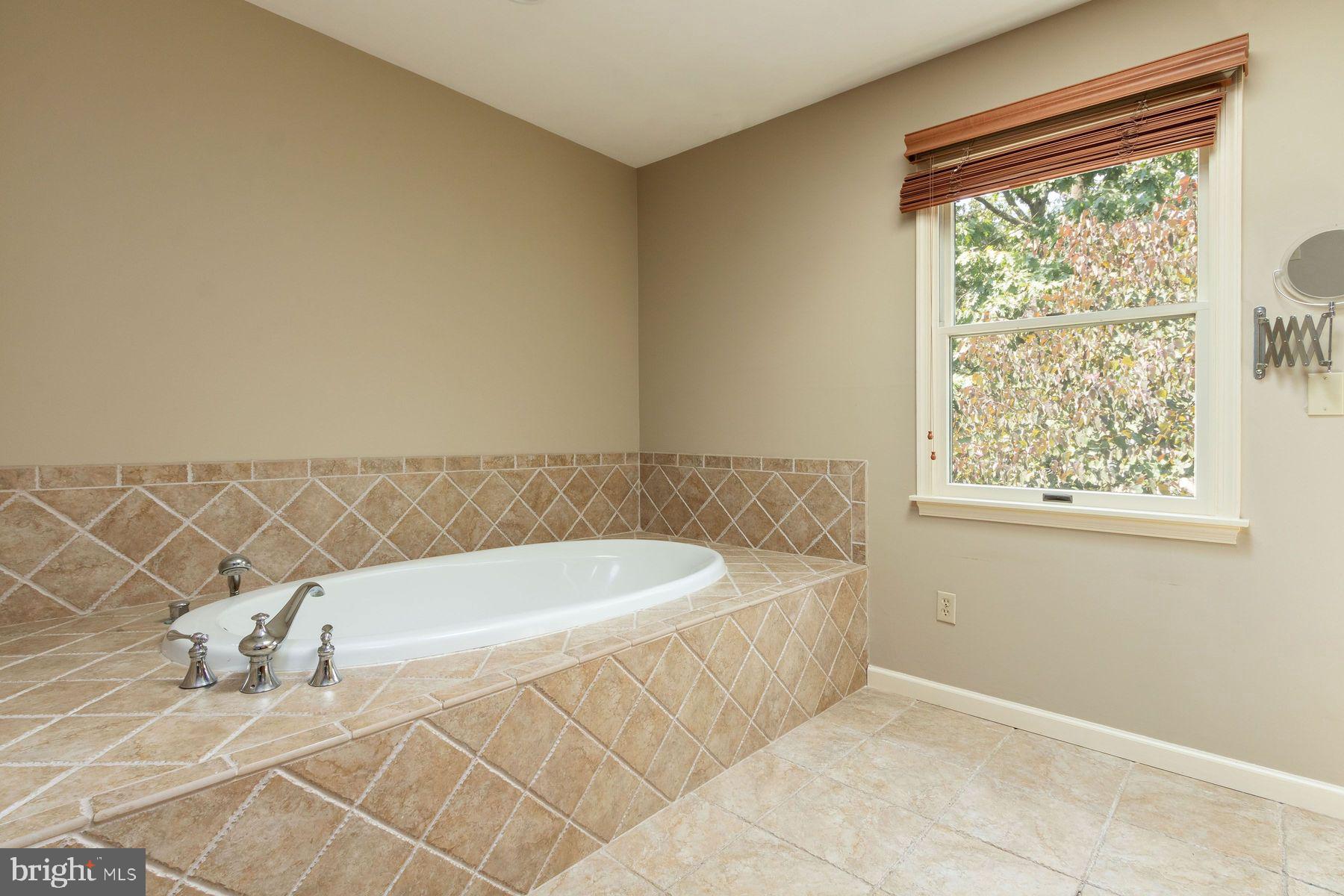 4887 Danielle Drive Doylestown, PA 18902 - Photo 29 of 35 a bath tub sitting next to a window and a wooden floor