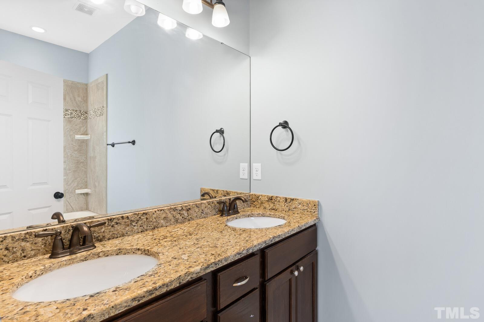 129 Pineland Circle, Unit 100 Raleigh, NC 27606 - Photo 11 of 29 a bathroom with a granite countertop sink and a mirror
