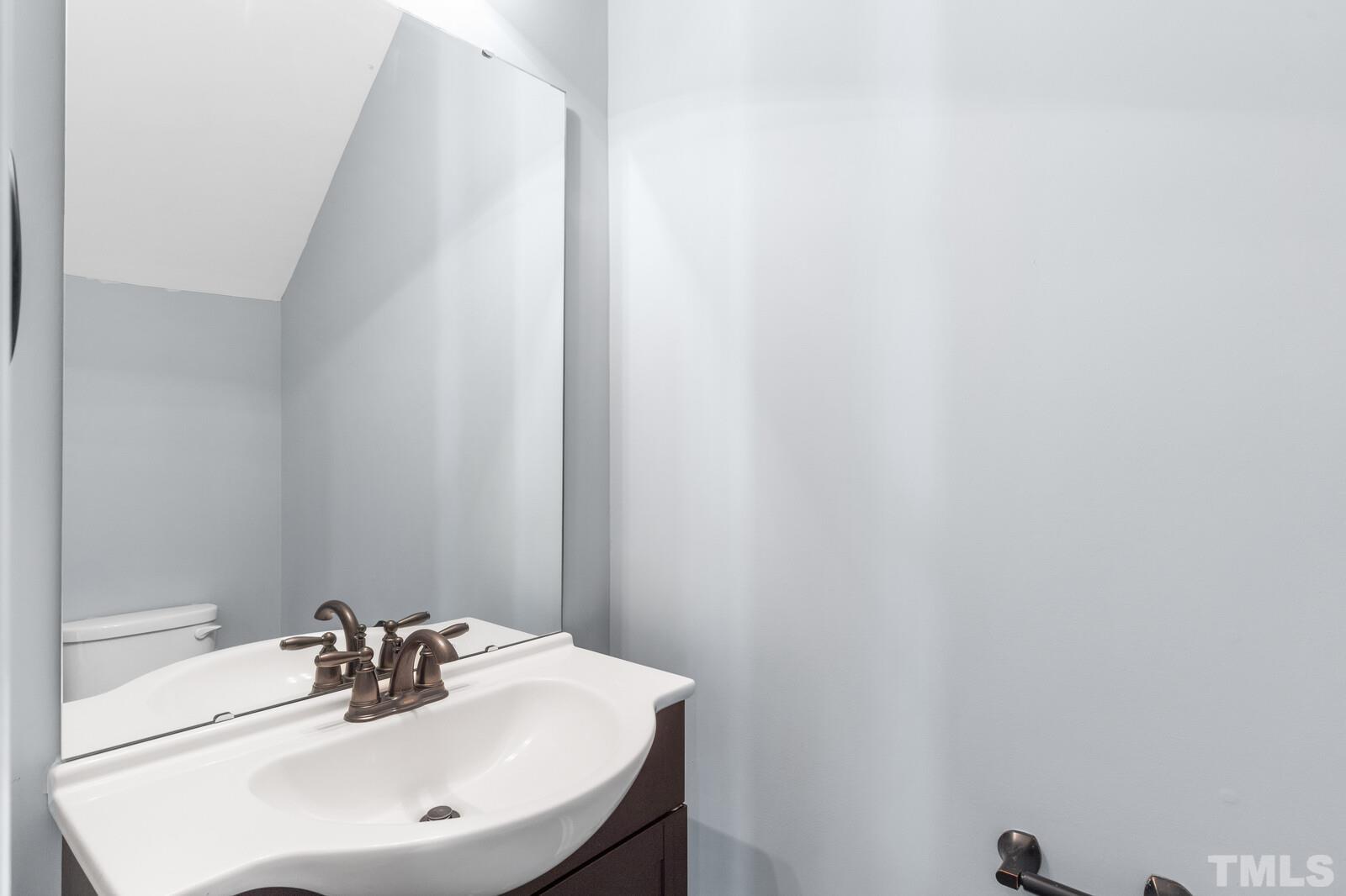 129 Pineland Circle, Unit 100 Raleigh, NC 27606 - Photo 12 of 29 a bathroom with a sink and a mirror