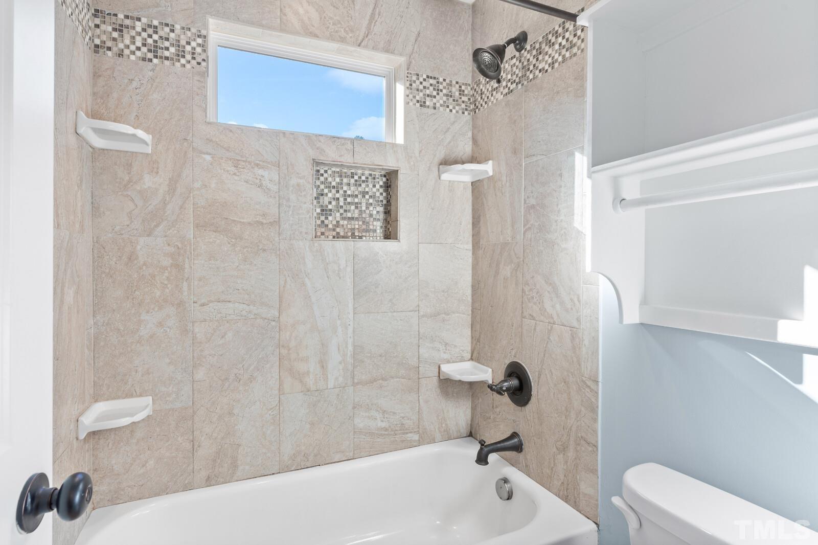 129 Pineland Circle, Unit 100 Raleigh, NC 27606 - Photo 14 of 29 a bathroom with a bathtub and shower