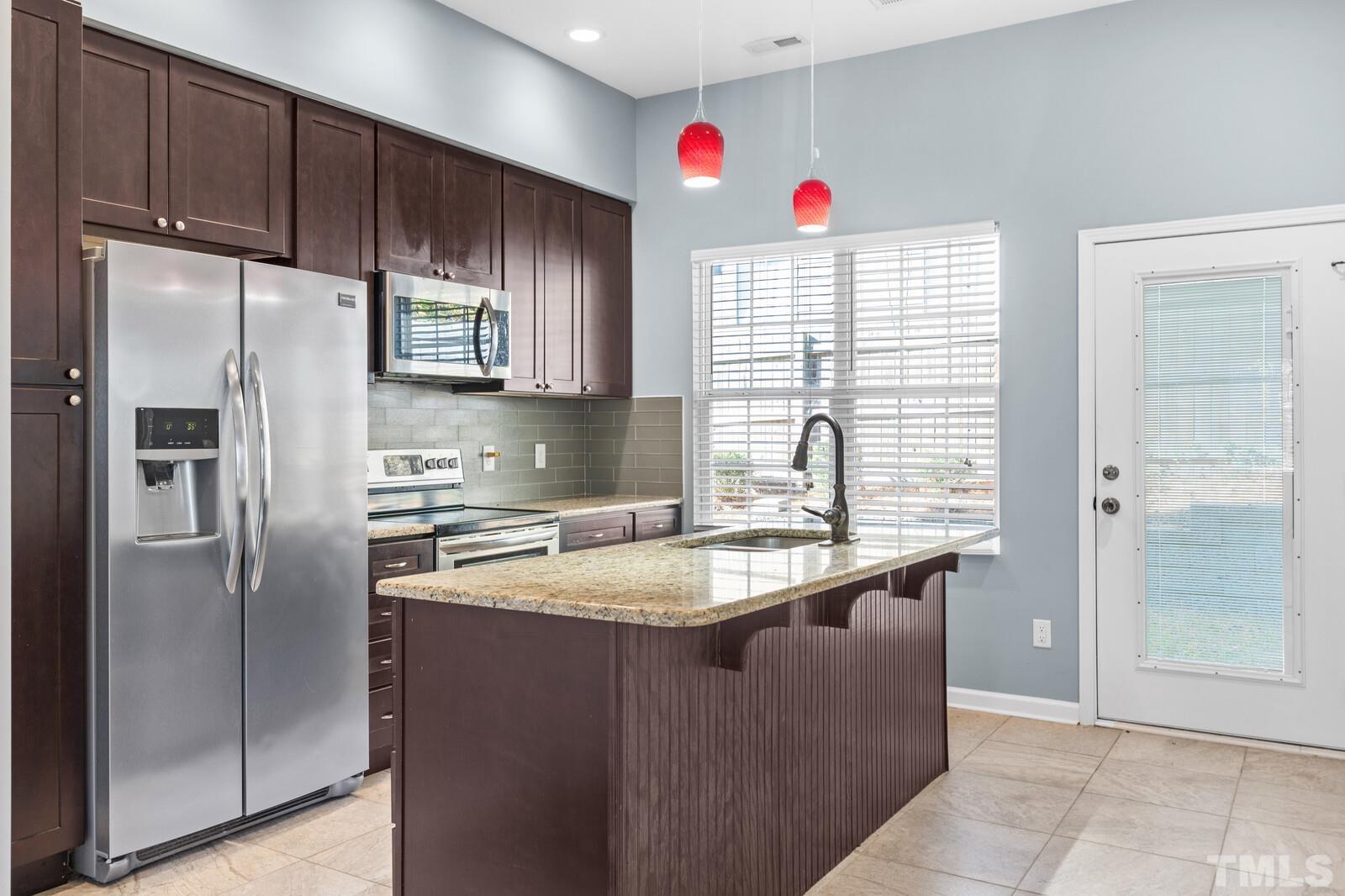 129 Pineland Circle, Unit 100 Raleigh, NC 27606 - Photo 21 of 29 a kitchen with stainless steel appliances granite countertop a refrigerator and a sink