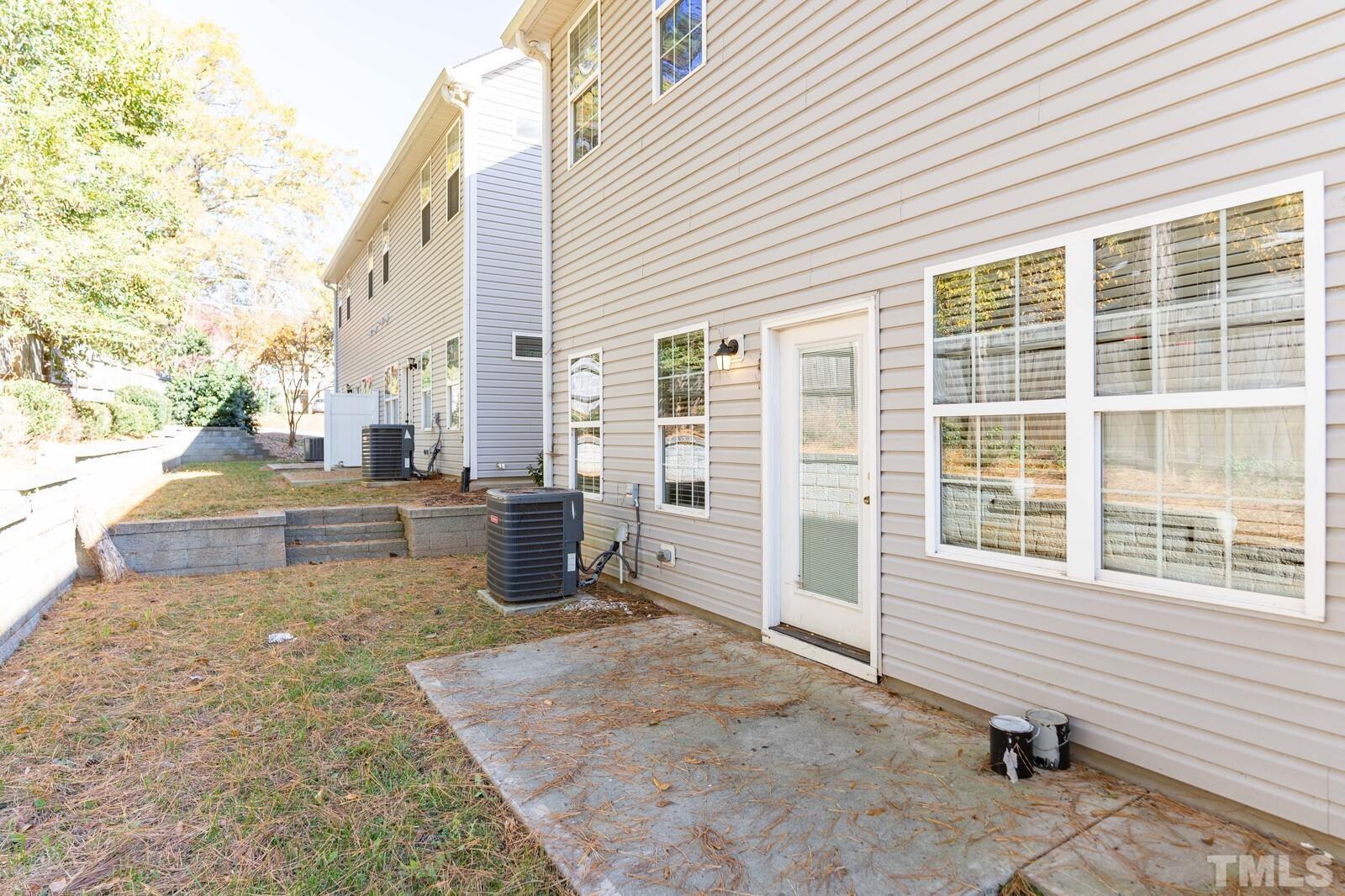129 Pineland Circle, Unit 100 Raleigh, NC 27606 - Photo 24 of 29 a view of a patio with table and chairs and floor to ceiling window