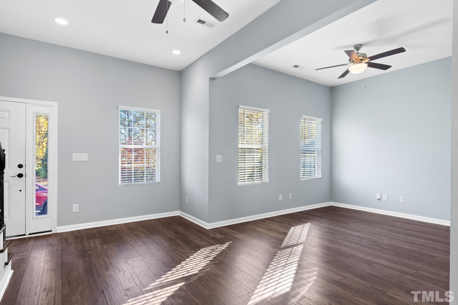 129 Pineland Circle, Unit 100 Raleigh, NC 27606 - Photo 5 of 29 a view of an empty room with wooden floor and a window