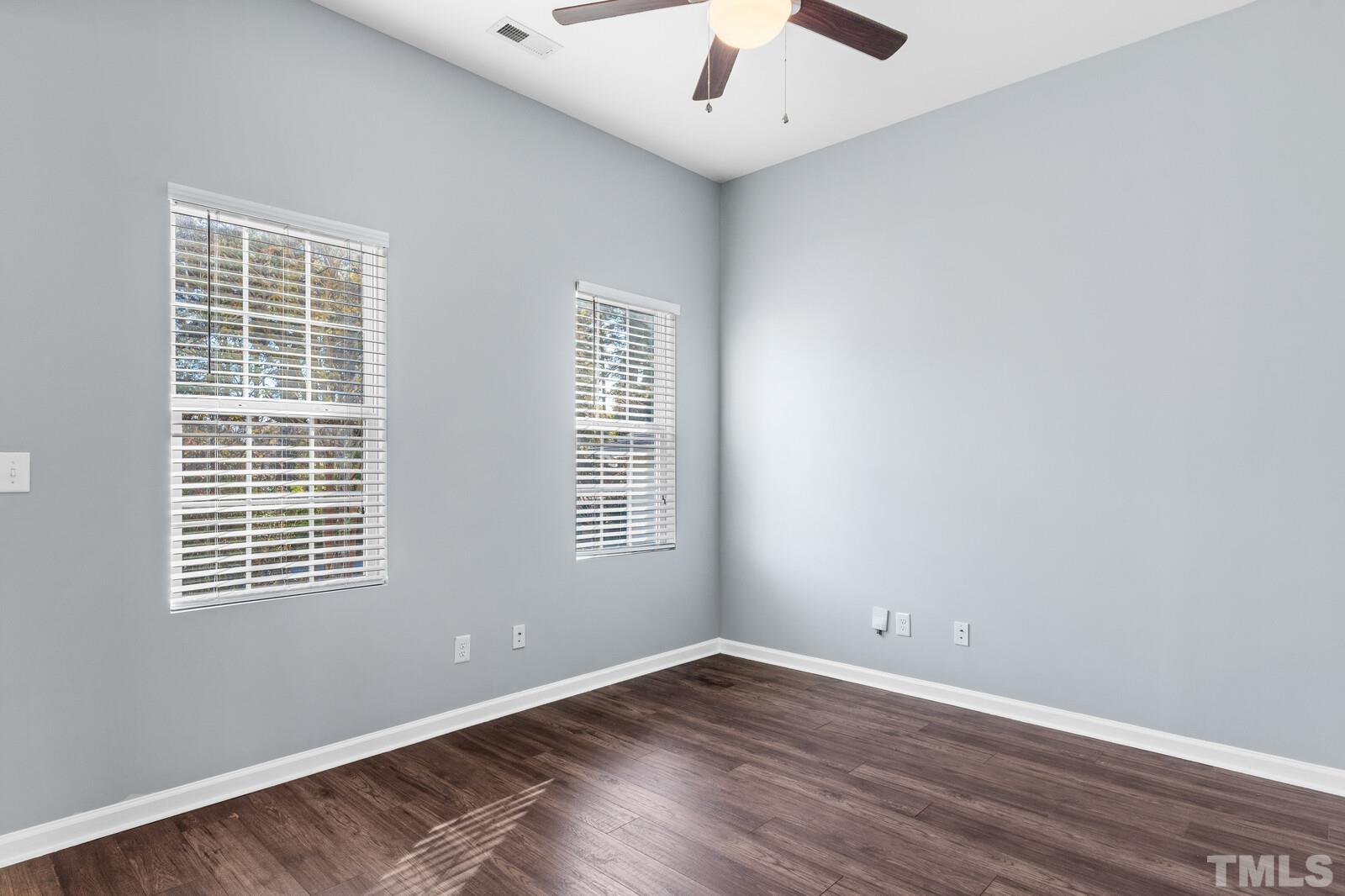 129 Pineland Circle, Unit 100 Raleigh, NC 27606 - Photo 6 of 29 an empty room with wooden floor and windows