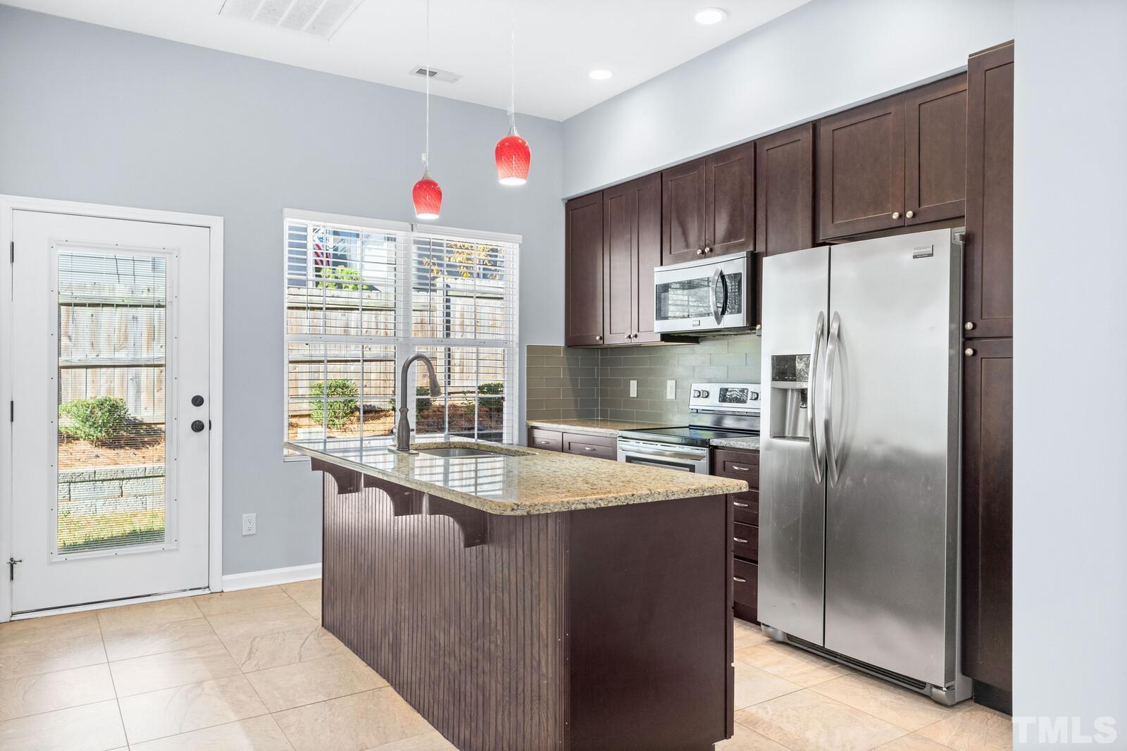 129 Pineland Circle, Unit 100 Raleigh, NC 27606 - Photo 7 of 29 a kitchen with stainless steel appliances granite countertop a refrigerator and a sink