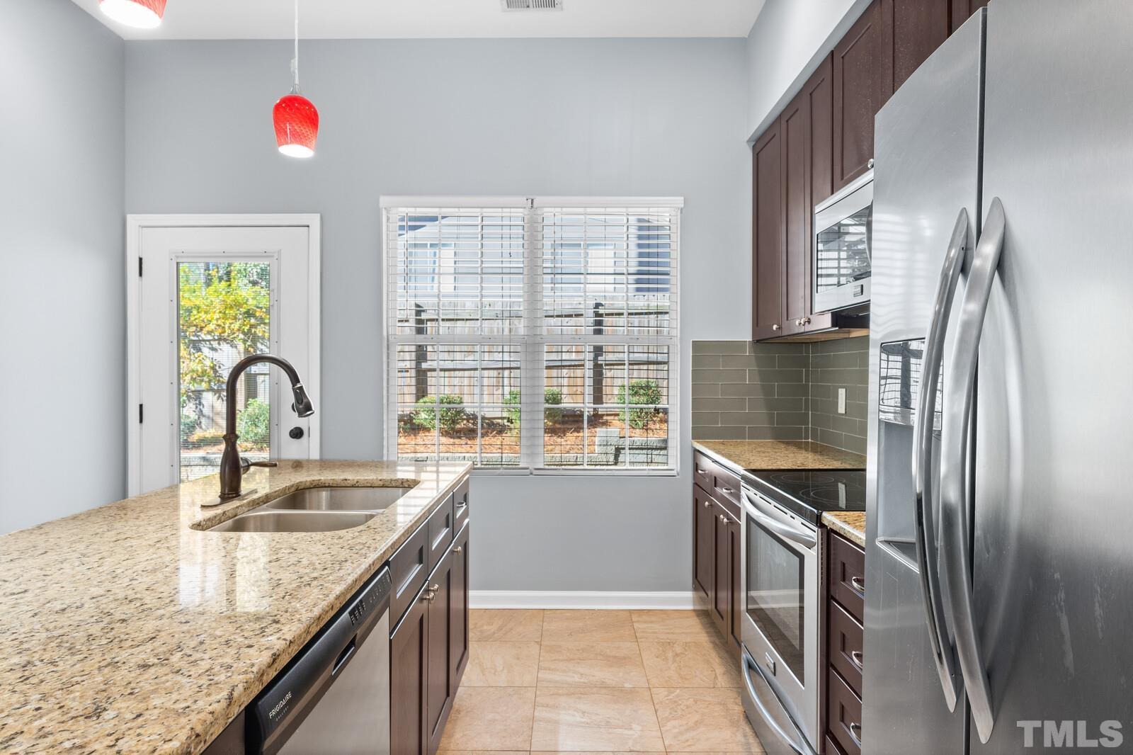 129 Pineland Circle, Unit 100 Raleigh, NC 27606 - Photo 9 of 29 a kitchen with granite countertop a sink and a stove
