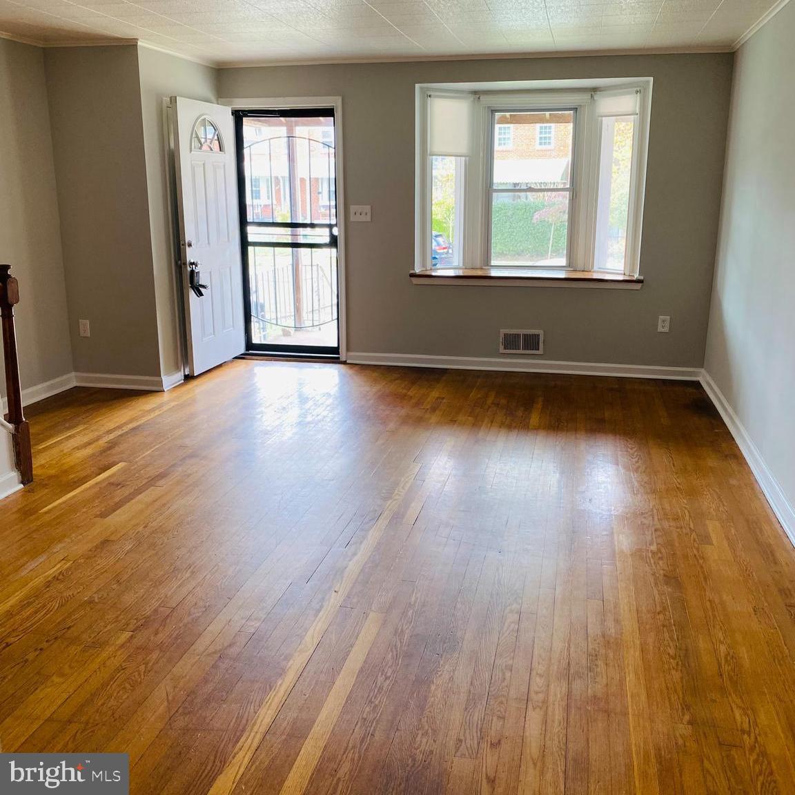 2073 Jasmine Road Dundalk, MD 21222 - Photo 3 of 12 an empty room with wooden floor and windows