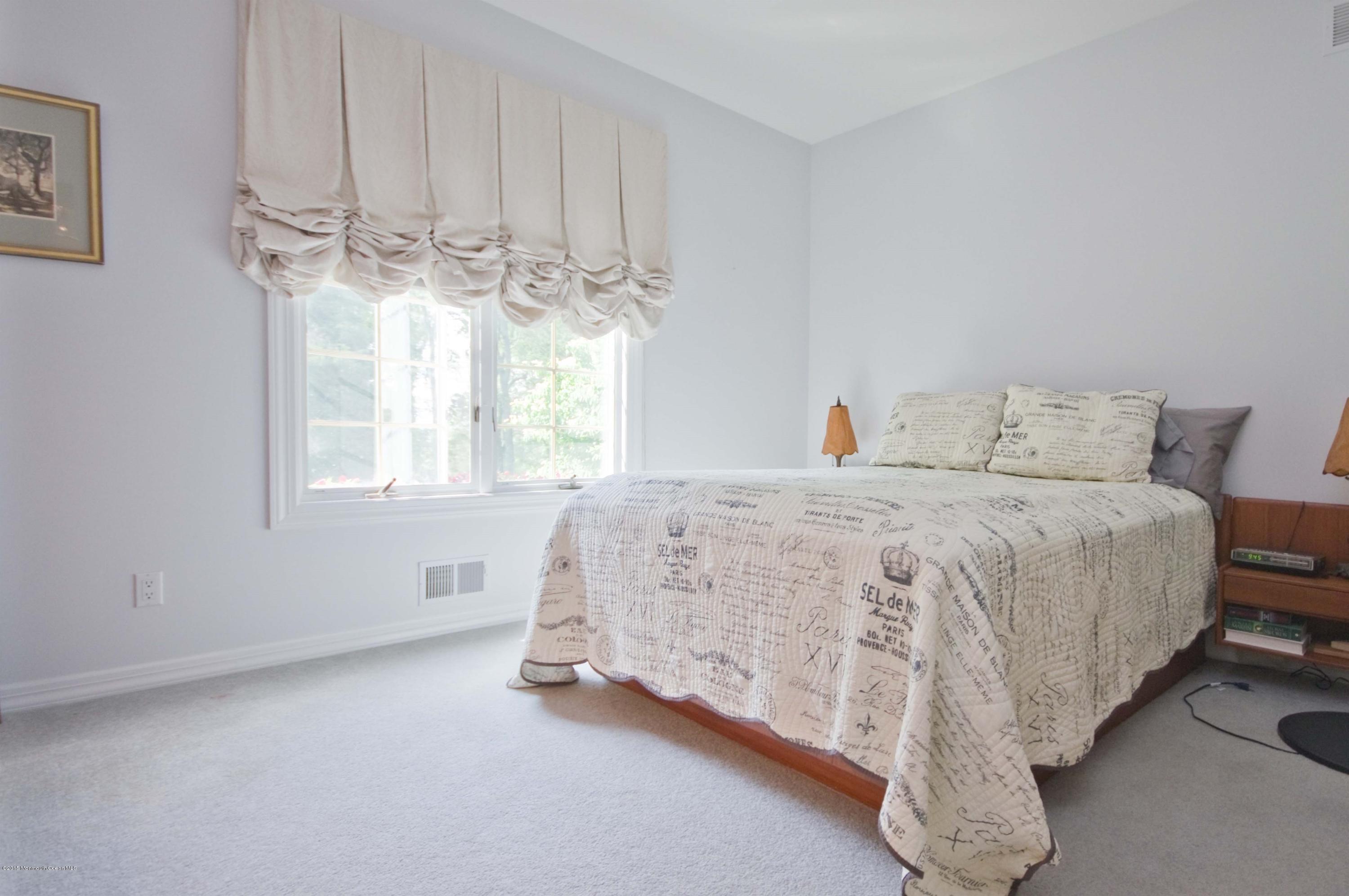 48 Crow Hill Road Freehold, NJ 07728 - Photo 17 of 29 a bedroom with a large bed and a chandelier