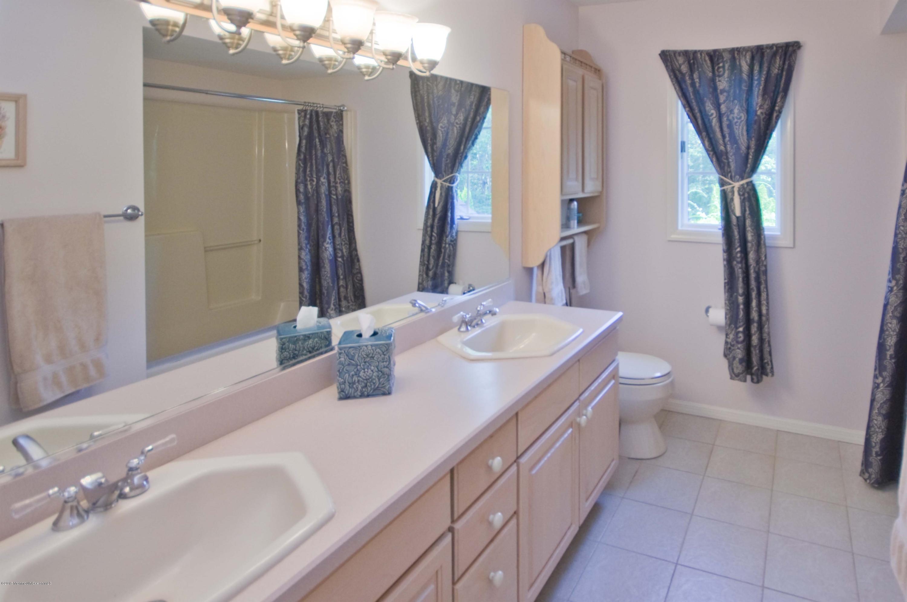 48 Crow Hill Road Freehold, NJ 07728 - Photo 22 of 29 a bathroom with a double vanity sink a toilet and a mirror