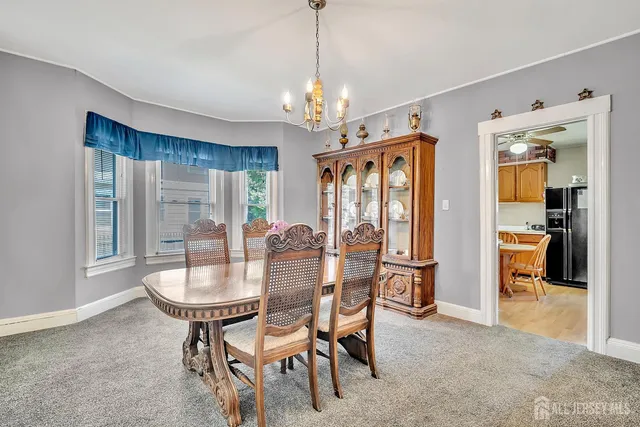 a dining room with furniture a chandelier and window