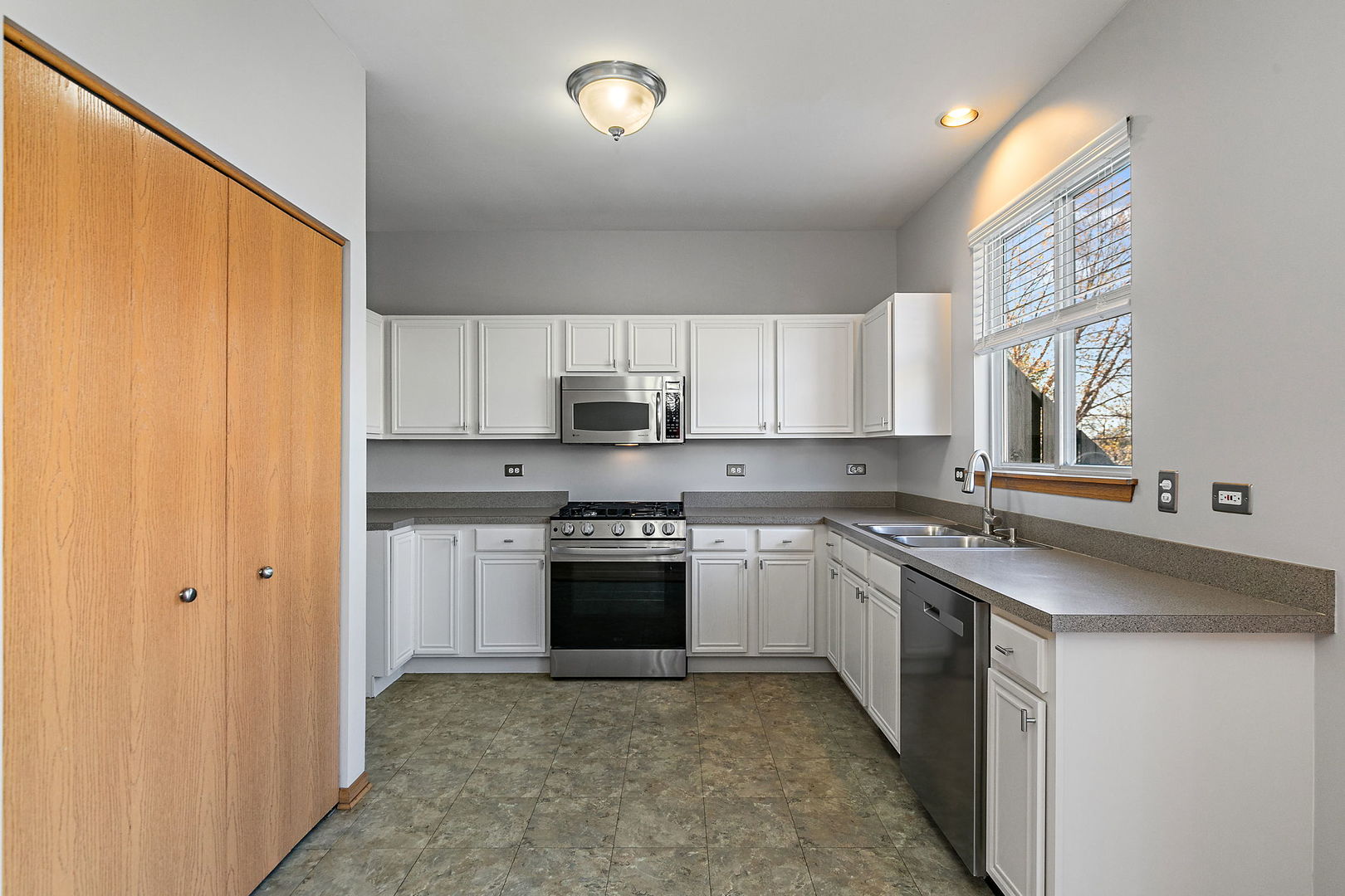 614 Littleton Trail Elgin, IL 60120 - Photo 13 of 29 a kitchen with stainless steel appliances granite countertop a stove a sink and a refrigerator