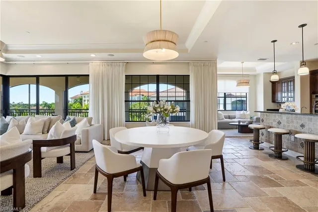 a dining room with furniture a chandelier and wooden floor