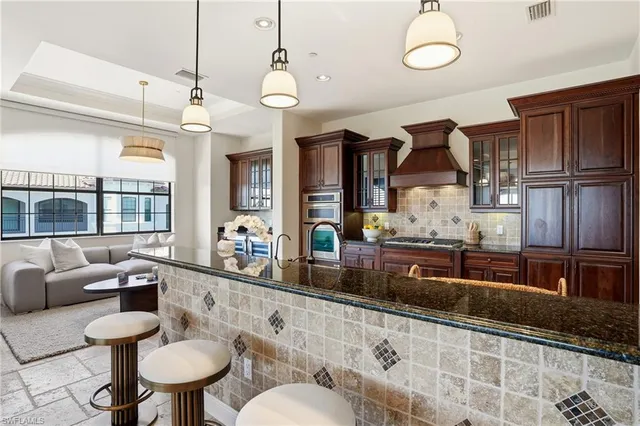 a kitchen with stainless steel appliances granite countertop a sink a stove and a refrigerator
