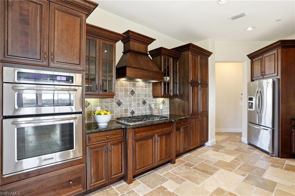 2546 Marquesa Royale Lane, Unit 7302 Naples, FL 34109 - Photo 18 of 46 a kitchen with stainless steel appliances granite countertop a refrigerator and a stove
