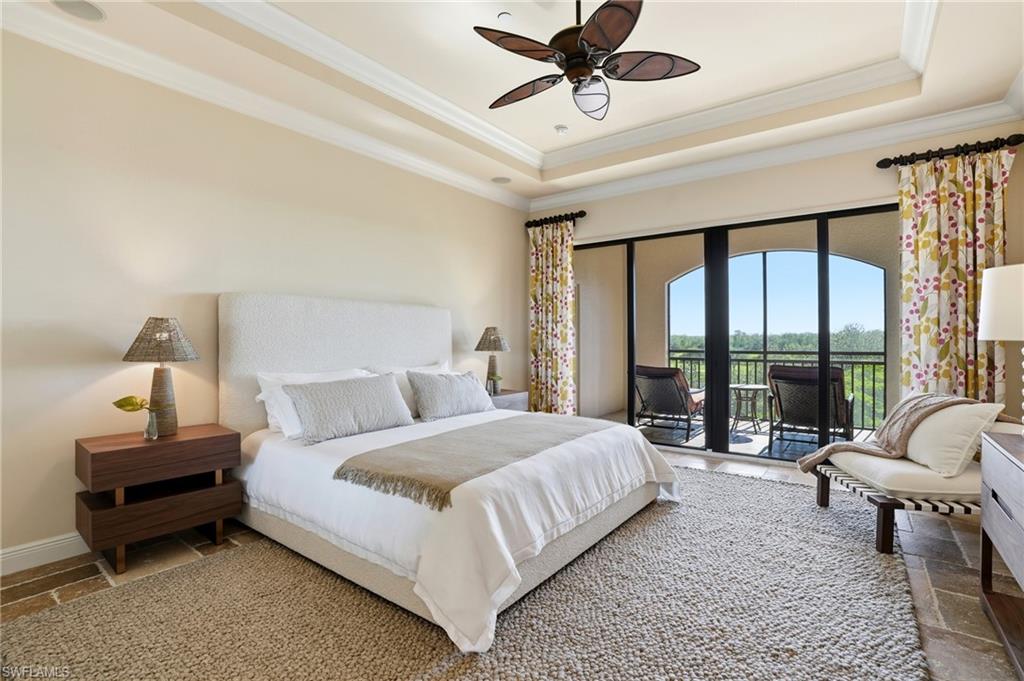 2546 Marquesa Royale Lane, Unit 7302 Naples, FL 34109 - Photo 21 of 46 a bedroom with a bed a couch and a large window