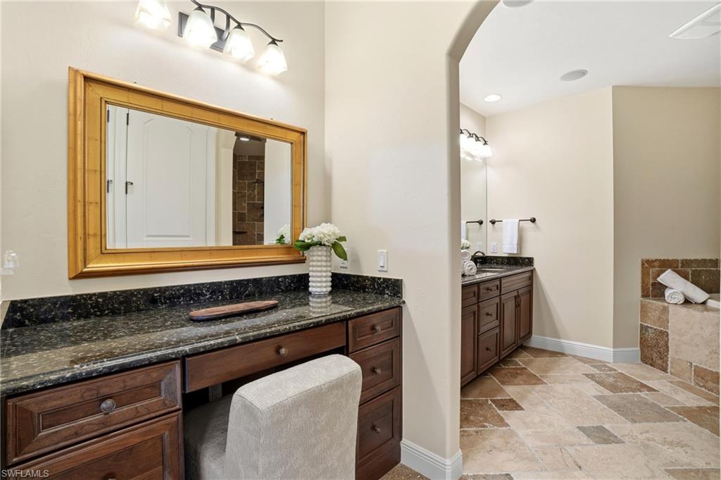 2546 Marquesa Royale Lane, Unit 7302 Naples, FL 34109 - Photo 24 of 46 a bathroom with a granite countertop sink and a mirror