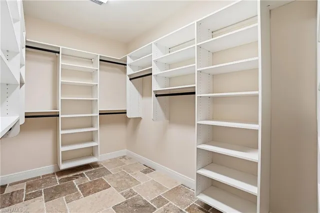 a view of walk in closet with empty racks