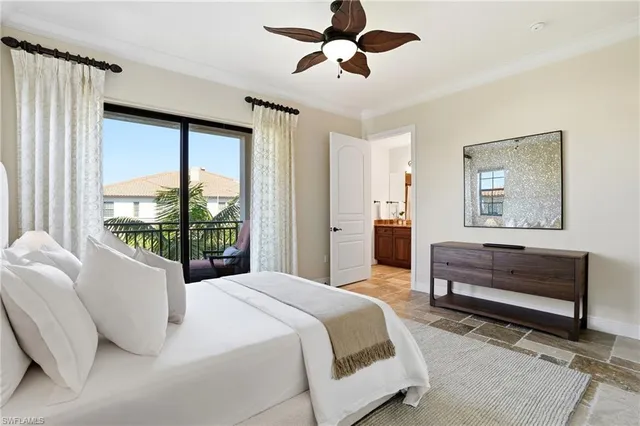 a bedroom with a bed painting on wall and a large window