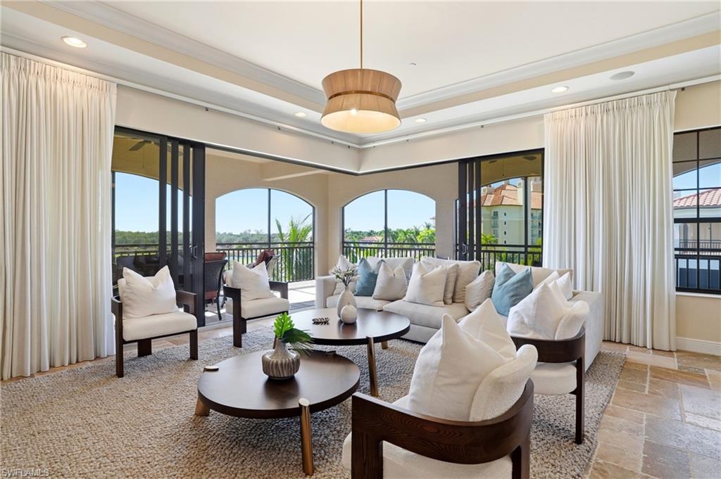 2546 Marquesa Royale Lane, Unit 7302 Naples, FL 34109 - Photo 5 of 46 a living room with furniture and a large window