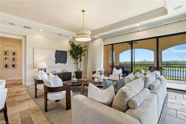 a living room with furniture chandelier and a large window