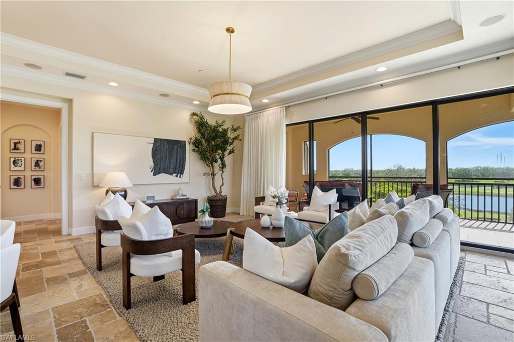 2546 Marquesa Royale Lane, Unit 7302 Naples, FL 34109 - Photo 8 of 46 a living room with furniture chandelier and a large window