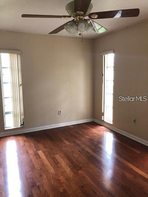 1271 Markham Avenue Spring Hill, FL 34606 - Photo 3 of 6 an empty room with wooden floor fan and windows