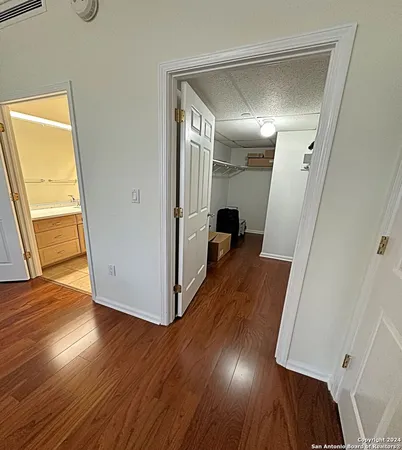 a view of a hallway with wooden floor and stairs