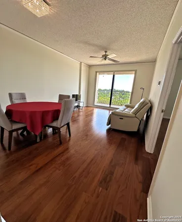 a living room with furniture floor to ceiling window and wooden floor